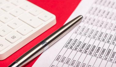 Kırmızı masada evrakları olan hesap makinesi. Belgeler ve finans