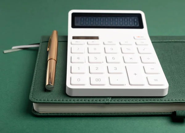 Calculator on green notepad or planner. Business accounting