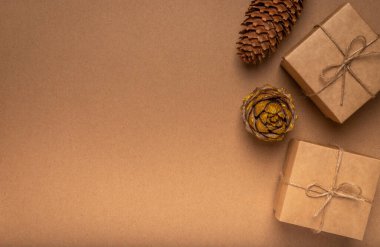 İki hediye kutusu, çam kozalağı ve jute telli el işi karton dokunun eko arka planı.