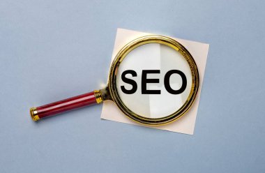 Mavi arkaplanda büyüteçle SEO kısaltması