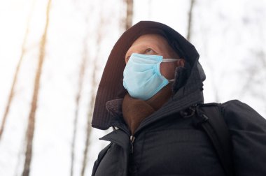 Sadece doğada maskeli yetişkin beyaz bir adam..