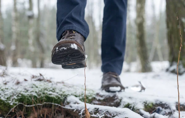 Kış ormanında öne çık. Çizmeli erkek bacakları.
