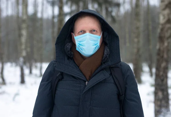 Adult caucasian man in face mask in nature alone.