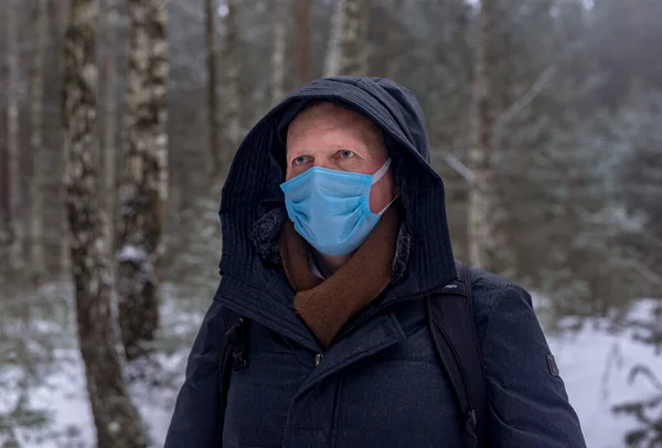 Adult caucasian man in face mask in nature alone.