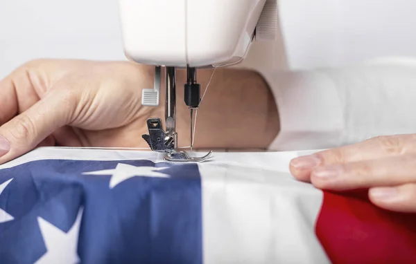 Erkek eller, bayramımız için dikiş makinesine Amerikan bayrağı dikiyor..