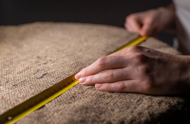 Dikiş işlemi. Yavaş moda kavramı. Ölçüm bandıyla keten kumaş ölçüsü.