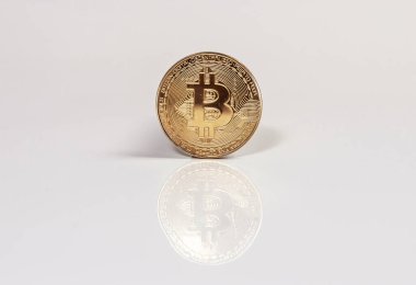 Beyaz arkaplanda yansımalı Bitcoin 'in altın sikkesi.