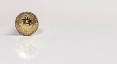 Beyaz arkaplanda yansımalı Bitcoin 'in altın sikkesi.