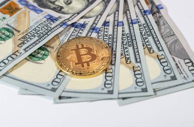 Bitcoin ya da BTC altın sikkesi, üzerinde dolar banknotlarının şifreleme işareti olan.