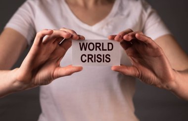 Dünya Krizi yazılı kağıt üzerinde kadınların ellerinde.