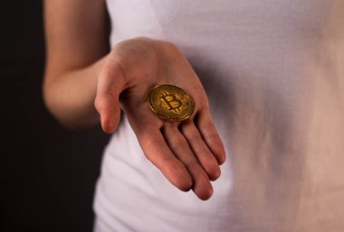 Bitcoin para kadın avucunun üzerinde yatıyor.