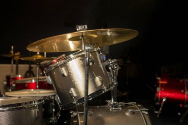 Siyah arka planda metal plakalı davul seti.