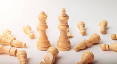 Beyaz satranç kralı ve kraliçesi düşmüş beyaz figürler arasında.