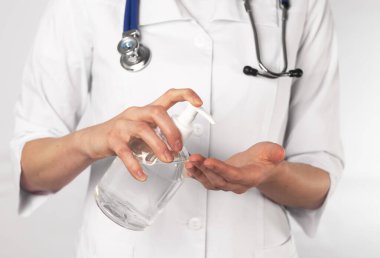 Doktor elleri antibakteriyel dezenfektan sürüyor ve ellerini yıkıyor..