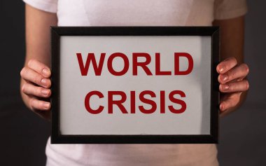 Dünya Krizi yazılı kağıt üzerinde kadınların ellerinde.