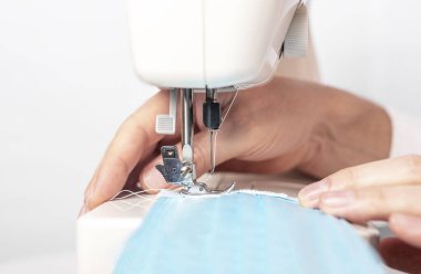 Makineye yüz maskesi dikerek ellerini kapat, erkek eli.