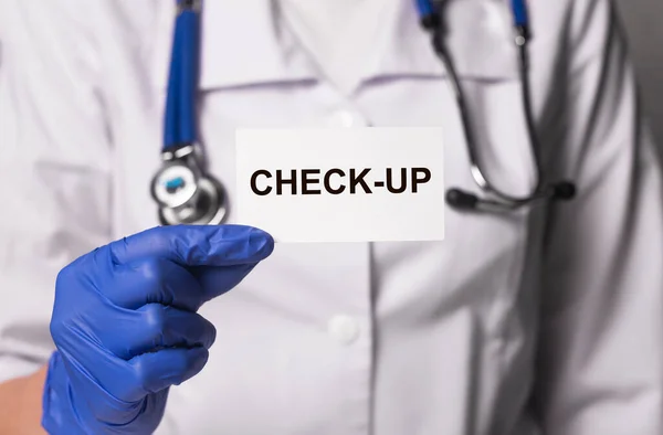 Medical check-up or health checkup. Inscription on paper in doctor hands.