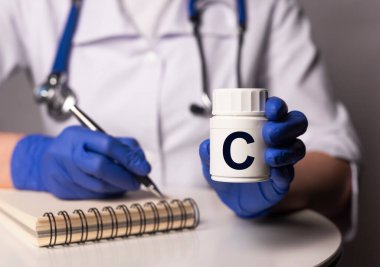 Doktor ellerinde beyaz kavanozda C vitamini, reçete..
