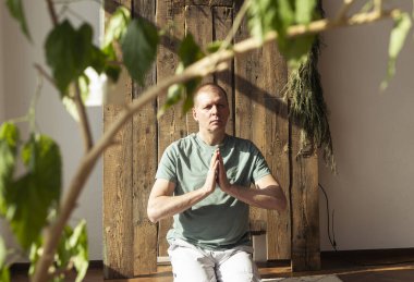 Olgun adam meditasyon yapıyor, gündüz vakti bitkilerle yoga ve meditasyon yapıyor..