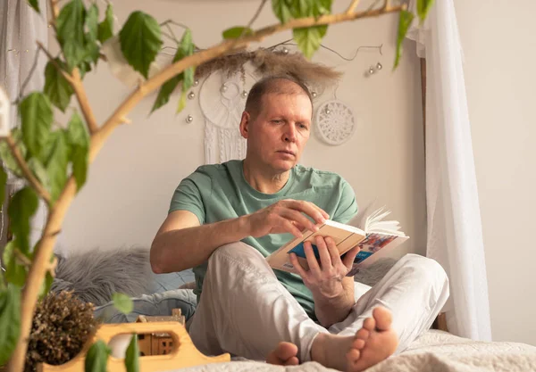 Ältere Kaukasische Mann Lesebuch Modernen Trendigen Gemütlichen Interieur Mit Pflanzen — Stockfoto