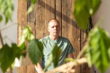 Olgun adam meditasyon yapıyor, gündüz vakti bitkilerle yoga ve meditasyon yapıyor..