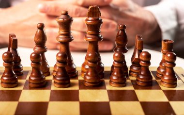 İş kurma ve kontrol etme kavramı. Erkek eli ve satranç tahtası patronun kontrolü altında..