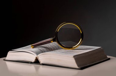 Sayfaları çevirerek ve büyüterek kitabı kapat. Masanın üzerinde sert bir kapakla ders kitabı. Öğrenim ve araştırma konsepti