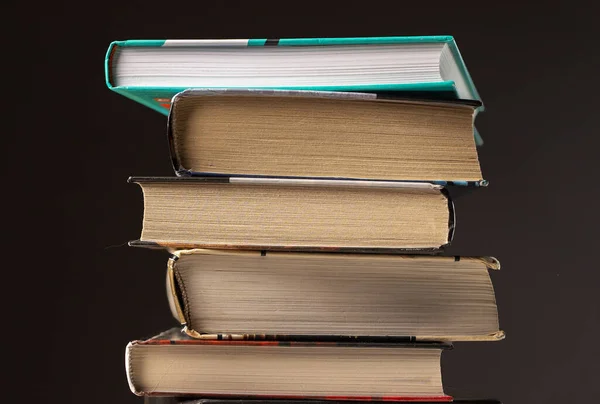 Högen eller stapeln av böcker, litteratur, läroböcker på mörk bakgrund — Stockfoto