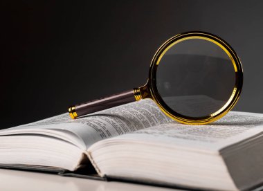 Sayfaları çevirerek ve büyüterek kitabı kapat. Masanın üzerinde sert bir kapakla ders kitabı. Öğrenim ve araştırma konsepti
