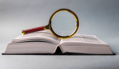 Sayfaları çevirerek ve büyüterek kitabı kapat. Masanın üzerinde sert bir kapakla ders kitabı. Öğrenim ve araştırma konsepti