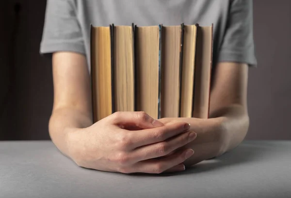 Book lover holding horizontal stack of books in hands, reader — Stock Photo, Image