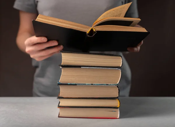 Kvinnliga studenthänder hålla och läsa bok, förbereda sig för examen, stack läroböcker. Utbildningsidé — Stockfoto