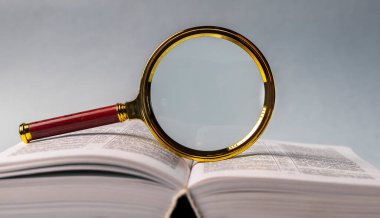 Sayfaları çevirerek ve büyüterek kitabı kapat. Masanın üzerinde sert bir kapakla ders kitabı. Öğrenim ve araştırma konsepti