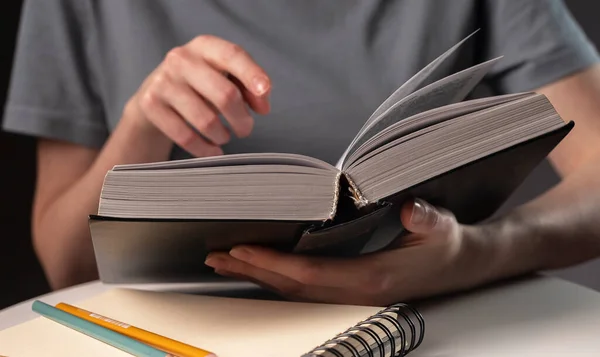 Ženské studentské ruce zblízka, ukazuje na text v knize nebo učebnici, hledá informace a čtení v noci — Stock fotografie