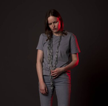 Zincirle bağlanmış genç bir kadın, umutsuzluktan muzdarip, psikolojik sorunlar. Ağır yük kavramına sahip mutsuz kişi