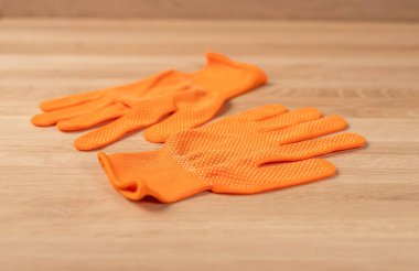 Turuncu bina ya da ahşap masadaki inşaat eldivenleri