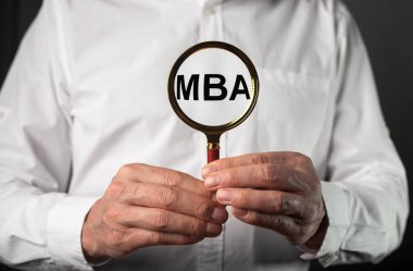 İşletme yönetimi diplomasının kısaltması. Eğitim konsepti. İş adamı elleri büyüteçle.