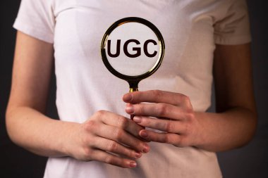 UGS veya Kullanıcı kaynaklı içerik kısaltması sosyal medya için kadın ellerindeki büyüteç ile