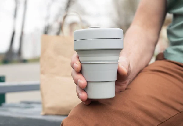 Składany silikonowy eko kubek do kawy na wynos. mężczyzna ręka z zrównoważony kubek — Zdjęcie stockowe