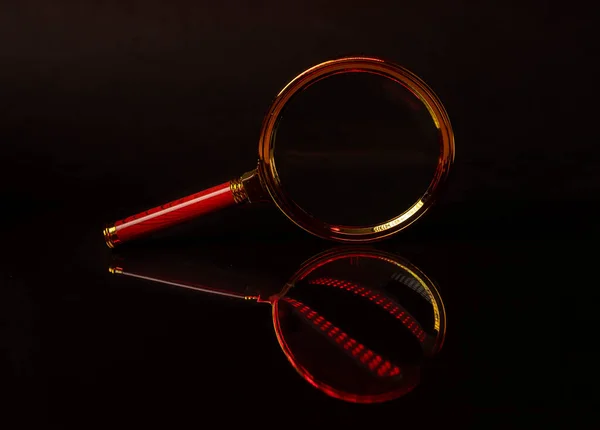 Altın metal büyüteç, koyu siyah arka planda yansımalı lens. Serch ve dedektif kavramı — Stok fotoğraf