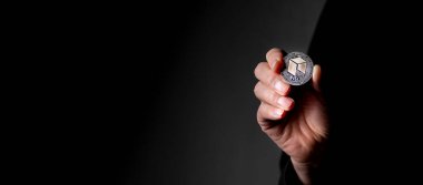 NEO gümüş kripto madeni para erkek elinde kopyalanmış siyah arkaplan