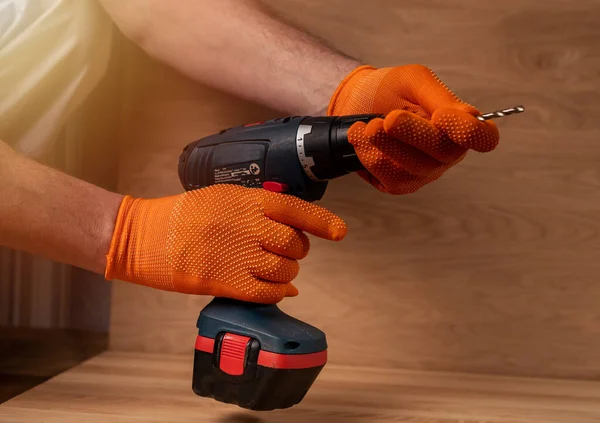 Mannelijke hand in het bouwen van handschoenen met professionele accuboor gereedschap of machine voor gebruik in reparatie en bouw — Stockfoto