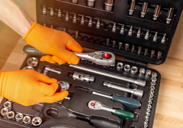 Mannelijke hand in het bouwen van handschoen met socket ratel handvat uit reparatie koffer. Industrieel gereedschap, close up — Stockfoto