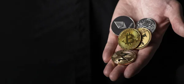 Bitcoin och andra olika cryptocurrency mynt i manlig hand handflata över svart bakgrund med kopia utrymme för text — Stockfoto