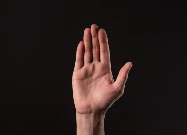 Erkek el hareketi siyah arka planda durur.