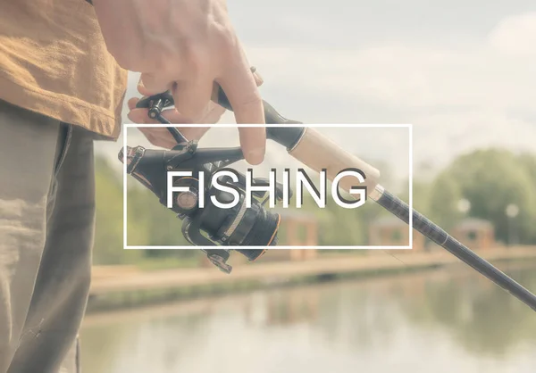 夏の日に手にリールロッドで閉じ漁師の手で写真のフレーム内の釣り言葉 — ストック写真