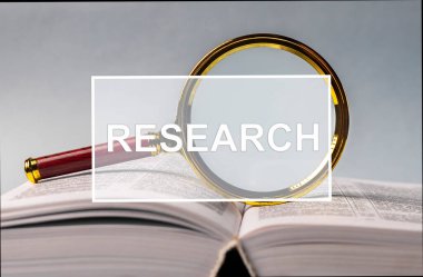 Büyüteçle açık bir kitap üzerinde kelime araştırması