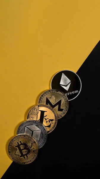 Different shining crypto currency coins. Bitcoin, litecoin, ethereum, monero and NEO on yellow and black vertical background with copy space — 스톡 사진