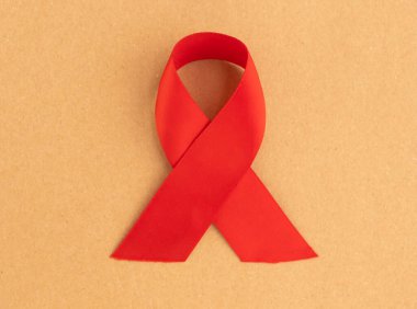 1 Aralık 'taki HIV ve AIDS farkındalık gününün sembolü olarak kırmızı saten kurdele ith döngüsü
