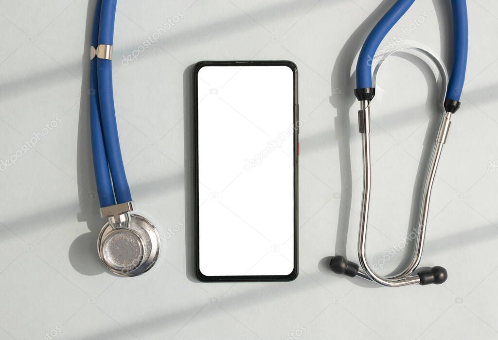 Mobile phone mock up for healthcare app. Smartphone white screen mock up and stethoscope for online health application